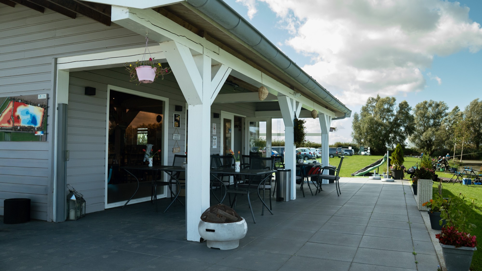Overdekt terras van de kantine met zicht op de visstekken